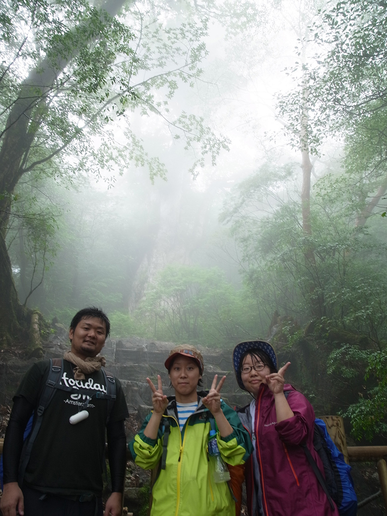 霧が立ちこめて縄文杉が霞んで見える中、縄文杉の前で3人一緒に記念撮影。