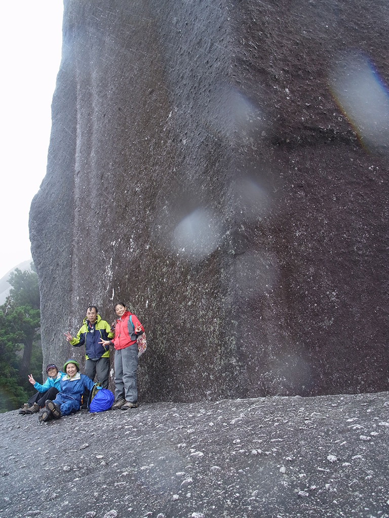 太忠岳山頂にそびえる高さ40mの天忠石をバックに登頂記念写真
