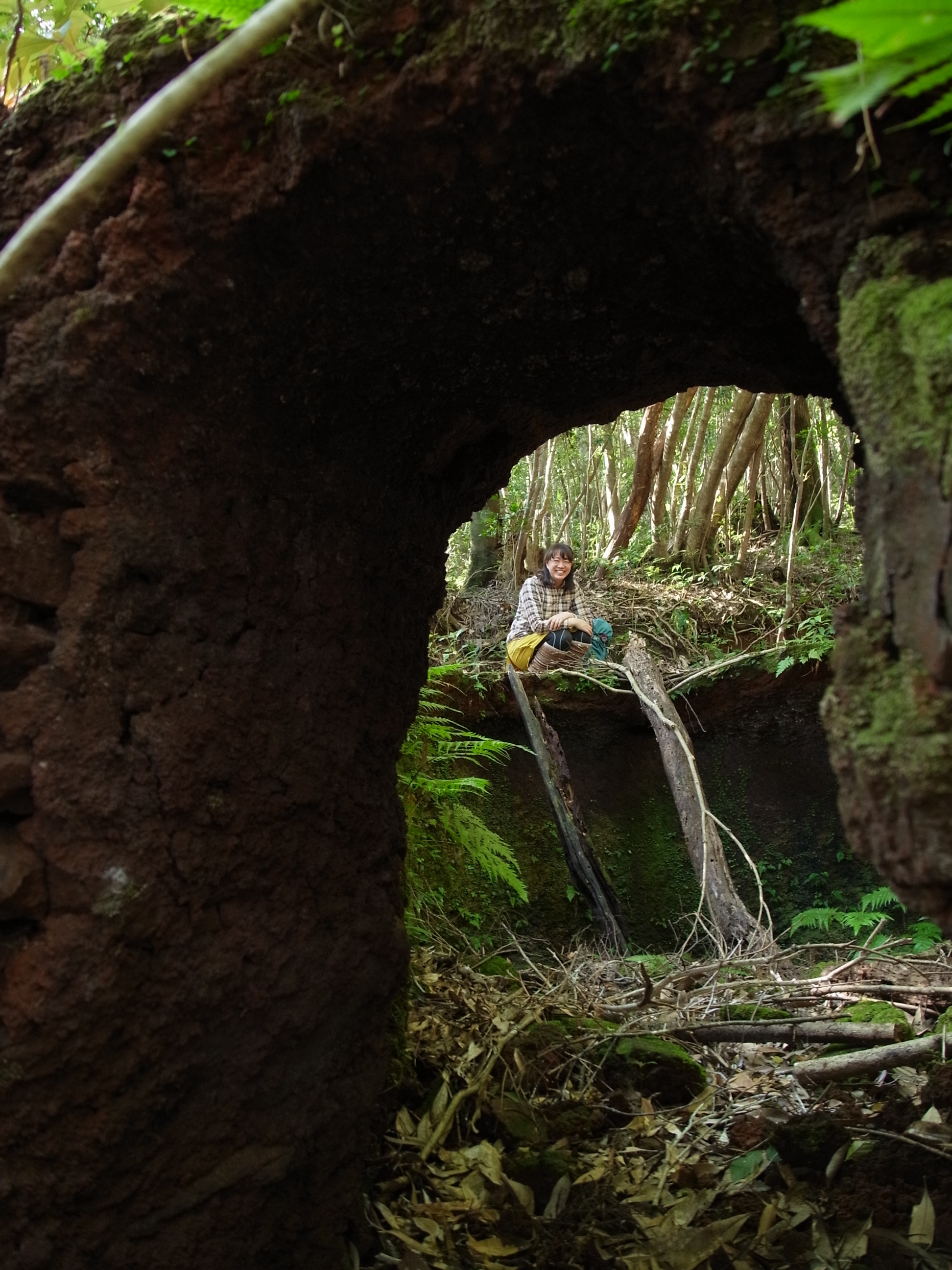 非常に状態がよく残っている炭焼き窯の入口から縁に座る参加者のRさんの写真