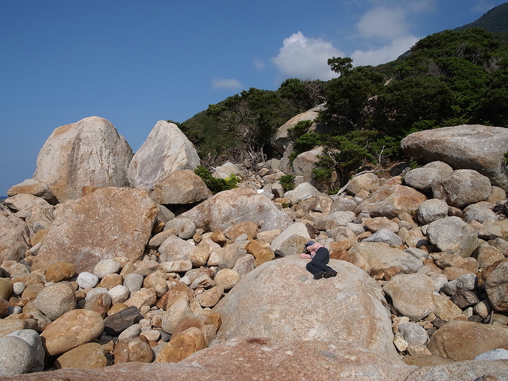 海岸線に転がる巨石の上で太陽の陽射しを感じてお昼寝中の参加者