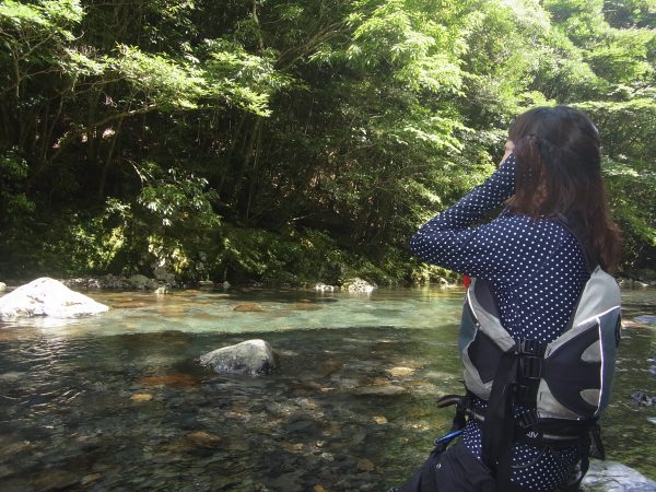 Kさんが両手を耳にあてて、沢の音が大きく聞こえてくるのを楽しんでいる様子