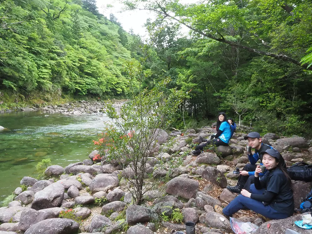河原でお茶タイムをしている４人の写真