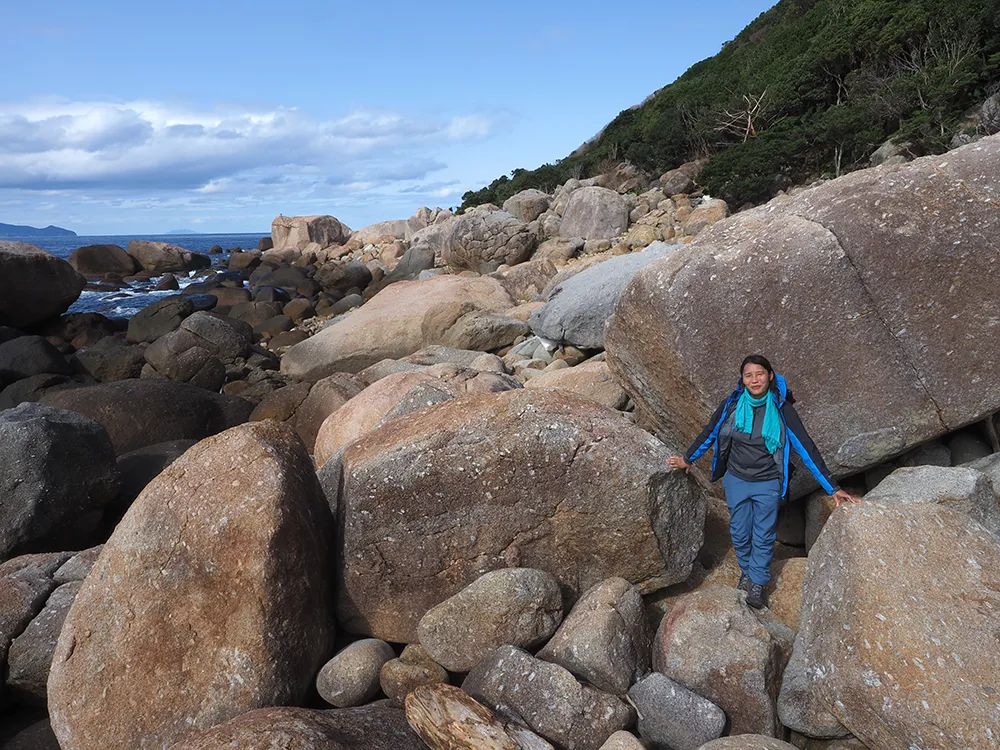 巨大な花崗岩に覆われる海岸線を歩く参加者
