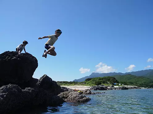 写真『子供が岩場から海に大ジャンプをしている瞬間』